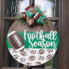 a football season door hanger is decorated with wreaths and decorations for the front door