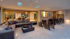 a living room filled with lots of furniture next to a dining room table and chairs