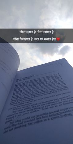 an open book sitting on top of a table next to a sky with clouds in the background