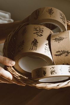 a person holding a wicker basket filled with washi tapes