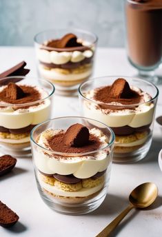 four desserts with chocolate and marshmallows in small glass dishes on a table