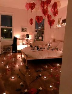 a bedroom decorated for valentine's day with balloons and confetti on the floor