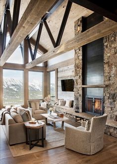 a living room filled with furniture and a fire place in the middle of a wooden floor