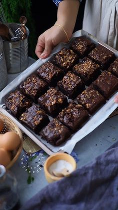 there is a tray of brownies on the table with eggs and other food items