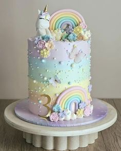 there is a cake decorated with rainbows and unicorns on the top of it