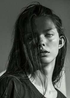 a black and white photo of a woman with wet hair