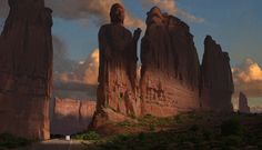 a person standing on the side of a road in front of large rocks and mountains