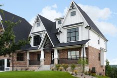 a large white house with black roof and windows