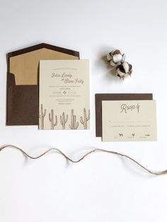 the wedding stationery is laid out on top of each other, including a card and envelope