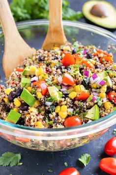 a glass bowl filled with mexican quisadilla salad and two wooden spoons