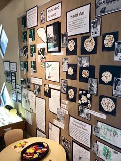 a wall covered in pictures and magnets next to a table with a plate on it