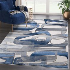 a blue and white area rug in a living room with a couch, chair and potted plant