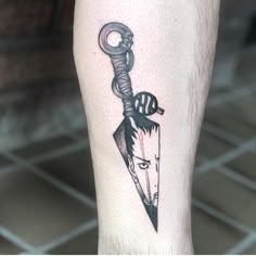 a man's leg with a black and white tattoo on it, holding a knife