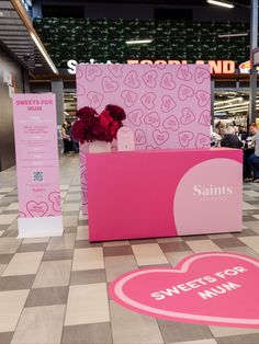 a pink counter sitting on top of a checkered floor next to a vase filled with flowers