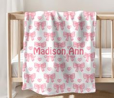 a baby crib with a pink and white blanket that says madison ann