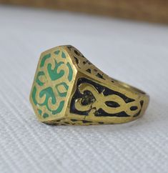 Vintage Berber Ethnic Ring in Antique Bronze Handmade with Green Enamel Pattern - Bague ethnique berbère Description: This unique handmade vintage ring is a rare and exquisite piece that showcases the rich heritage of Berber craftsmanship. The ring is made of bronze and features an intricate Green enamel design, adding a touch of elegance and cultural significance. This ethnic Berber ring is a perfect blend of tradition and artistry, making it a standout addition to any jewelry collection. Produ Traditional Green Rings, Traditional Handmade Green Rings, Bohemian Gold Jewelry With Inlay, Gold Bohemian Jewelry With Inlay, Antique Handmade Green Ring, Vintage Handmade Brass Rings, Vintage Bronze Brass Rings, Ceremonial Symbolic Brass Rings, Tiny Trinkets