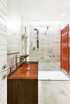 a bathroom with a shower, sink and toilet in it's corner area next to a red radiator