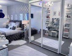 a bedroom with mirrored walls and furniture in the corner, along with a chandelier hanging from the ceiling