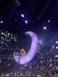 a person sitting on the moon at a concert