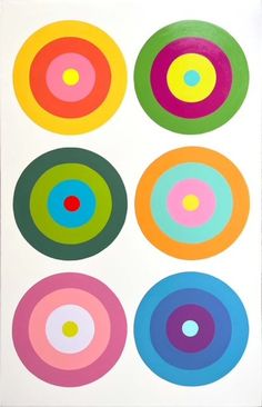 four circles are arranged in different colors and sizes on a white paper background, with the center circle surrounded by smaller circles