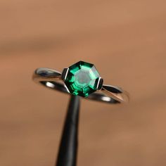 It is a lab emerald ring. The main stone is 7 mm*7 mm octagon cut.weight about 1.25  caratsThe basic metal is sterling silver and plated with rhodium.To change the metal to a solid gold (white/rose) or platinum is also available, please ask for a quotation if you want.You can also go to my shop Home for more elegant rings: https://www.etsy.com/shop/godjewelry?ref=hdr_shop_menu Emerald is May birthstone More emerald rings:https://www.etsy.com/shop/godjewelry?ref=seller-platform-mcnav&section_ Diamond Cut Octagon Emerald Ring, Emerald Ring With Diamond Cut In Octagon Shape, Silver Emerald Ring With Octagon Diamond Cut, Green Emerald Solitaire Crystal Ring, Green Octagon Emerald Ring With Diamond Cut, Octagon Emerald Ring In Sterling Silver With Prong Setting, Octagon Emerald Ring With Prong Setting In Sterling Silver, Octagon White Gold Emerald Ring, Green Octagon Diamond Cut Ring