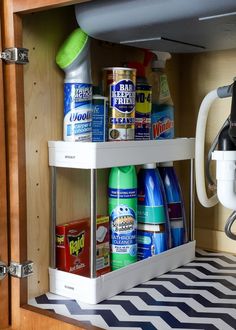 the kitchen cabinet is filled with cleaning products