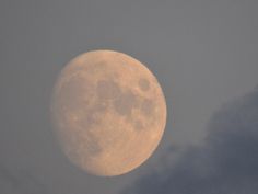 the full moon is seen through dark clouds