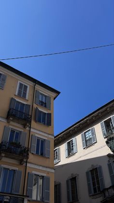 an apartment building with windows and balconies against a blue sky in the background