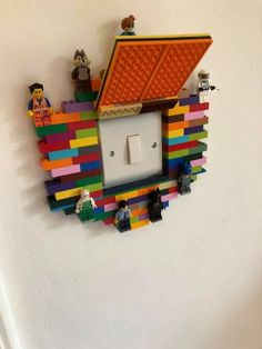 an electrical outlet cover made out of legos and other toys on a white wall