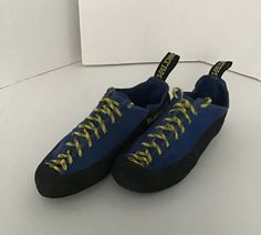 a pair of blue sneakers with yellow laces on the bottom and black soles