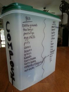 a large container sitting on top of a wooden table next to a wall with writing on it