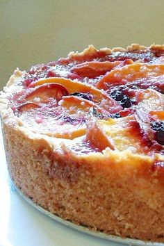 a cake sitting on top of a white plate with fruit toppings and frosting