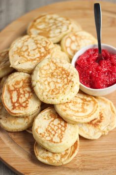 pancakes on a wooden plate with raspberry sauce