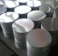 stacks of white and black plates sitting on top of a metal table next to each other