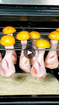 chickens are being cooked in an oven with lemons on the rack and chicken legs