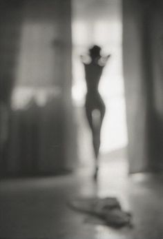 a black and white photo of a woman's body in the middle of a room