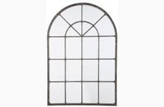 a tall arched window with an iron frame and glass panes on the top, against a white background