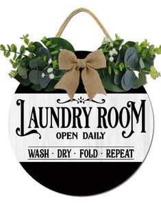 the laundry room open daily sign is decorated with greenery and bow ties on it