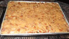 a pan filled with food sitting on top of a metal rack next to an oven