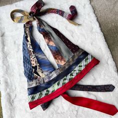 several ties laid out on a white blanket