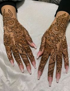 two hands with henna designs on them