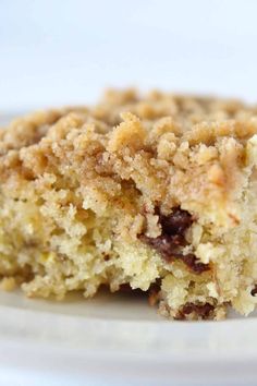 a close up of a piece of cake on a plate with crumbled toppings