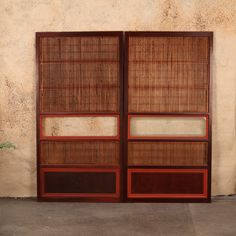 two wooden doors with different shades of brown and red in front of a stucco wall