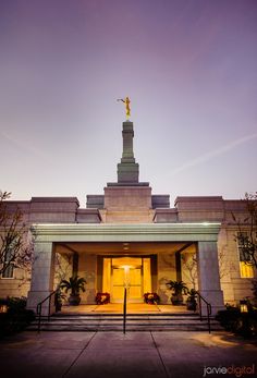 the front entrance of a building with a statue on top