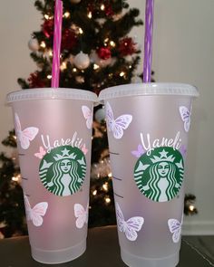 two starbucks cups sitting next to each other