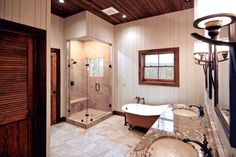 a large bathroom with two sinks and a bathtub in the middle of the room