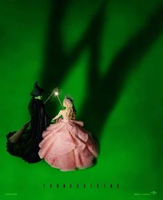 two figurines in black and pink gowns on a green background with the words thanksgiving giving