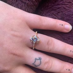 a woman's hand with a tattoo on it and a ring in the middle