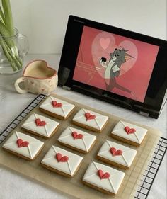 there are many decorated cookies on the table next to a vase with tulips