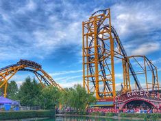 an amusement park with roller coasters in the water and people riding on top of them